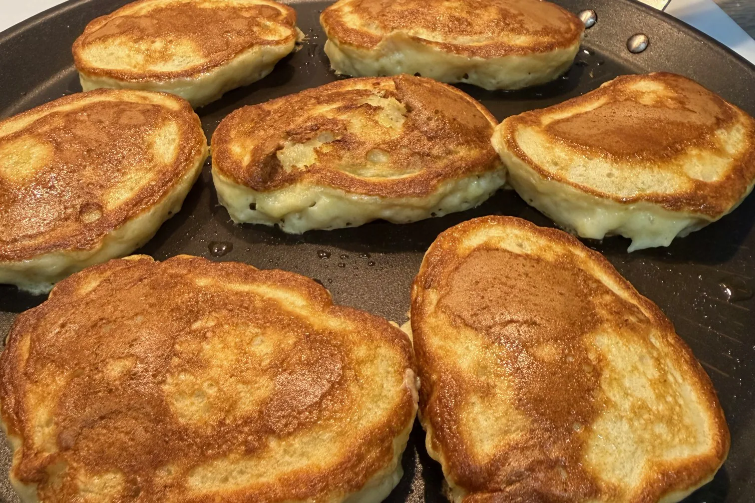 Thick irregular banana pancakes cooked until golden brown on a pan
