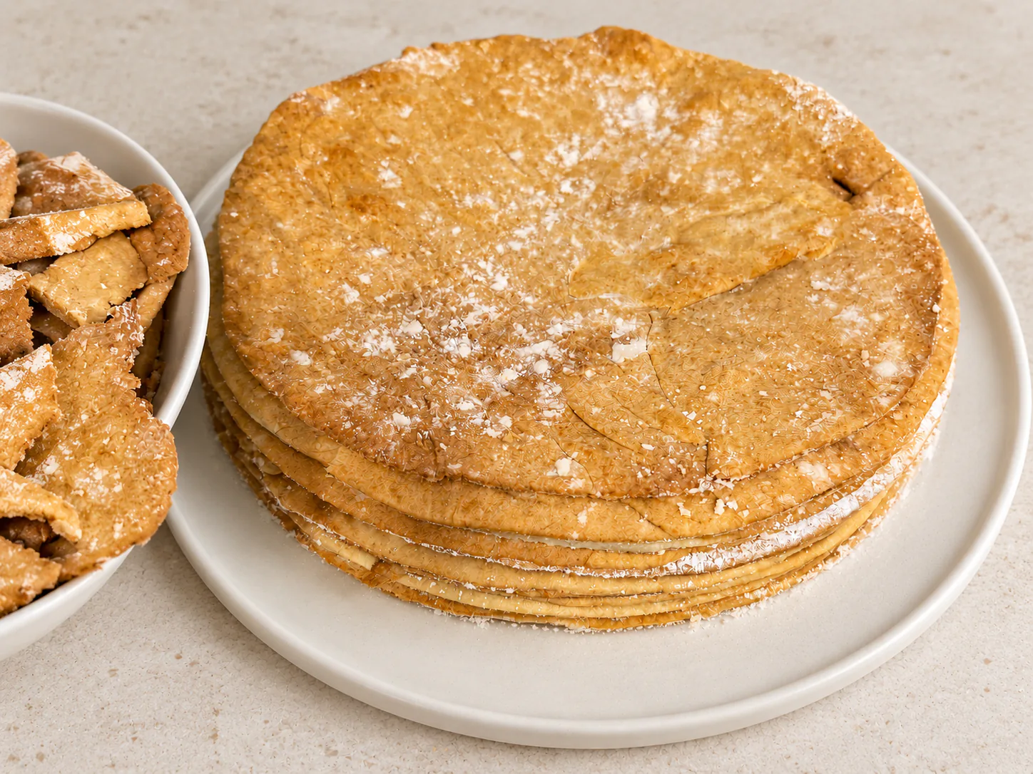 A stack of golden Napoleon layers with baked trimmings alongside