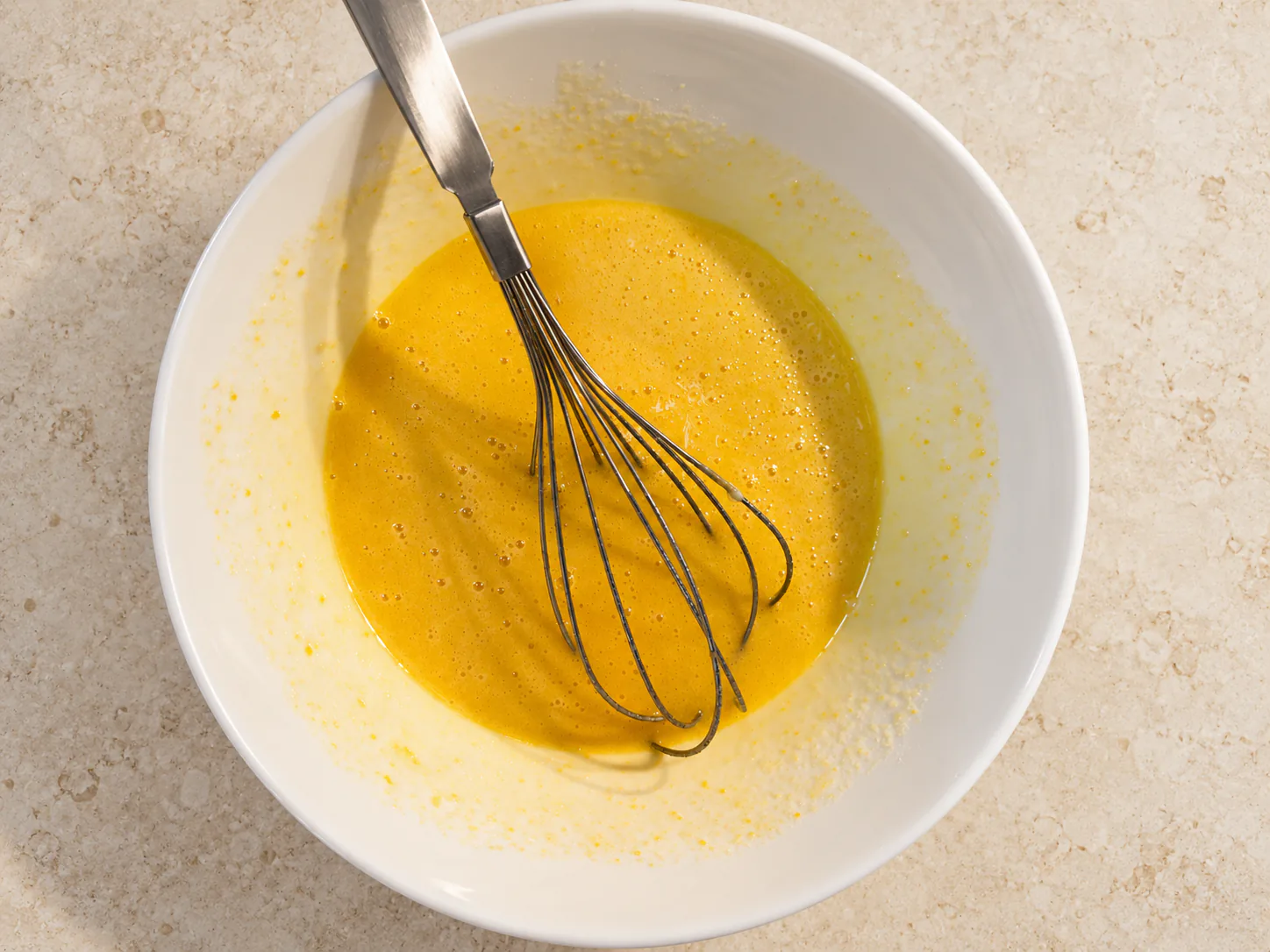 Smooth egg mixture with a whisk in the bowl