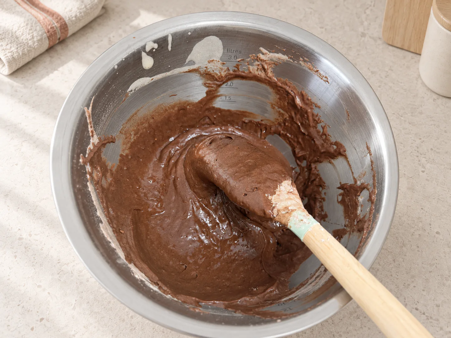 Chocolate batter on a spatula in a metal bowl