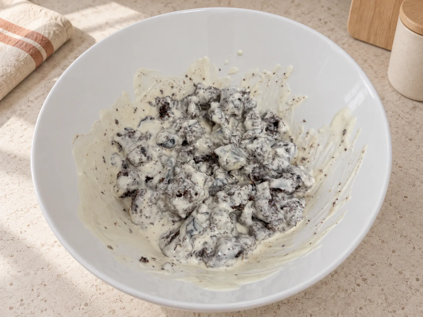 Chocolate cake pieces coated in cream in a white bowl
