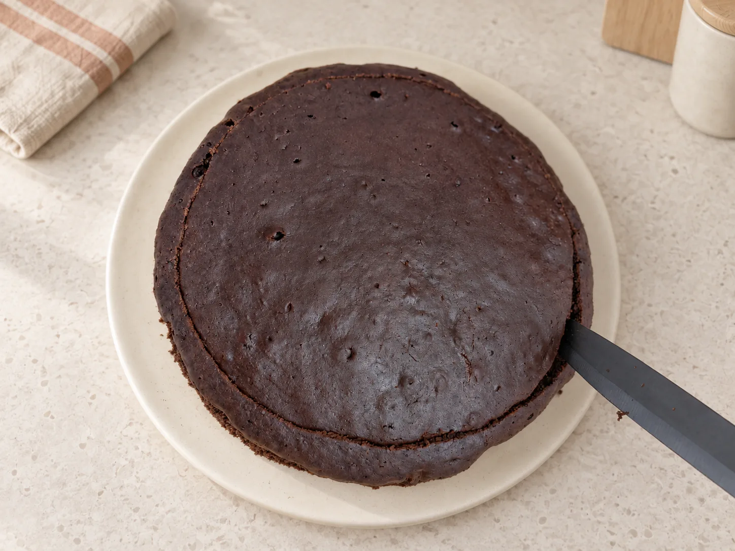 Knife cutting a narrow strip around the cake edge